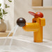Golden dog-shaped basin faucet installed in a warm modern bathroom